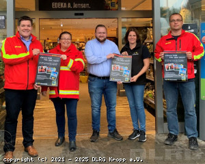 Thies O. Wolfhagen (DLRG LV SH), Nadine Tams-Detlefsen (DLRG Kropp), Marcel Fischer (EDEKA Jensen), Rike Büttner (Marktleiterin) und Jochen Reimer (DLRG Kropp) freuen sich über das Spendenjubiläum und zeigen mit den bisherigen Dankesplakaten der vergangenen fünf Jahre den herausragenden Verlauf der Spenden-Kampagne im EDEKA-neukauf Jensen in Kropp. (Foto: Ute Reimers)